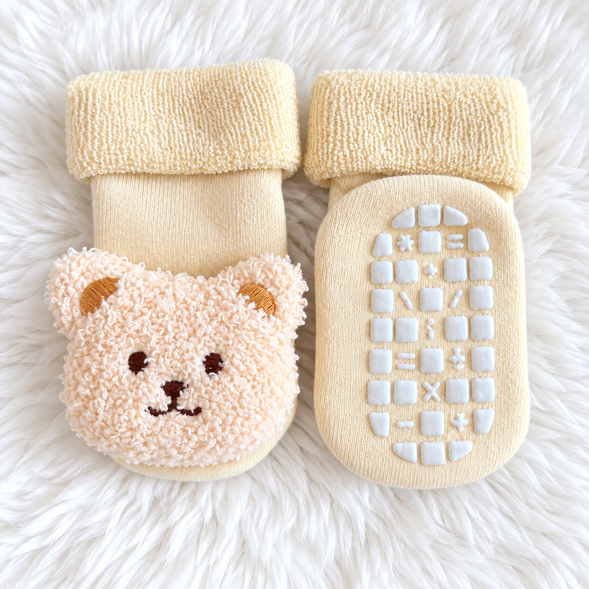 Cream bear baby non-slip socks on white rug background