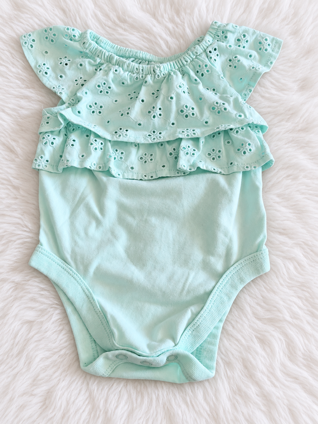 Garanimals mint eyelet ruffle bodysuit on a soft white rug