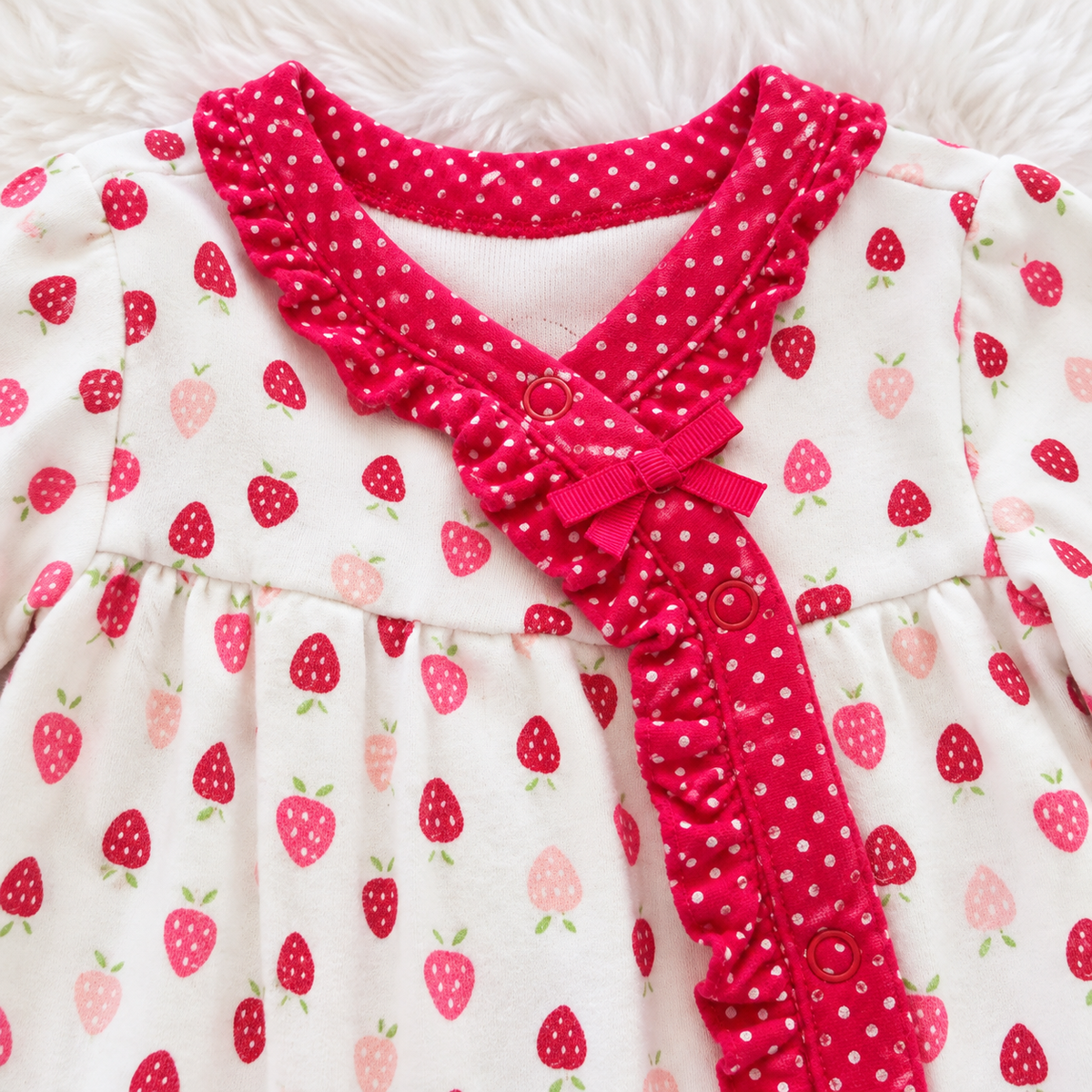 Close-up of Gymboree strawberry print sleeper ruffle trim and bow