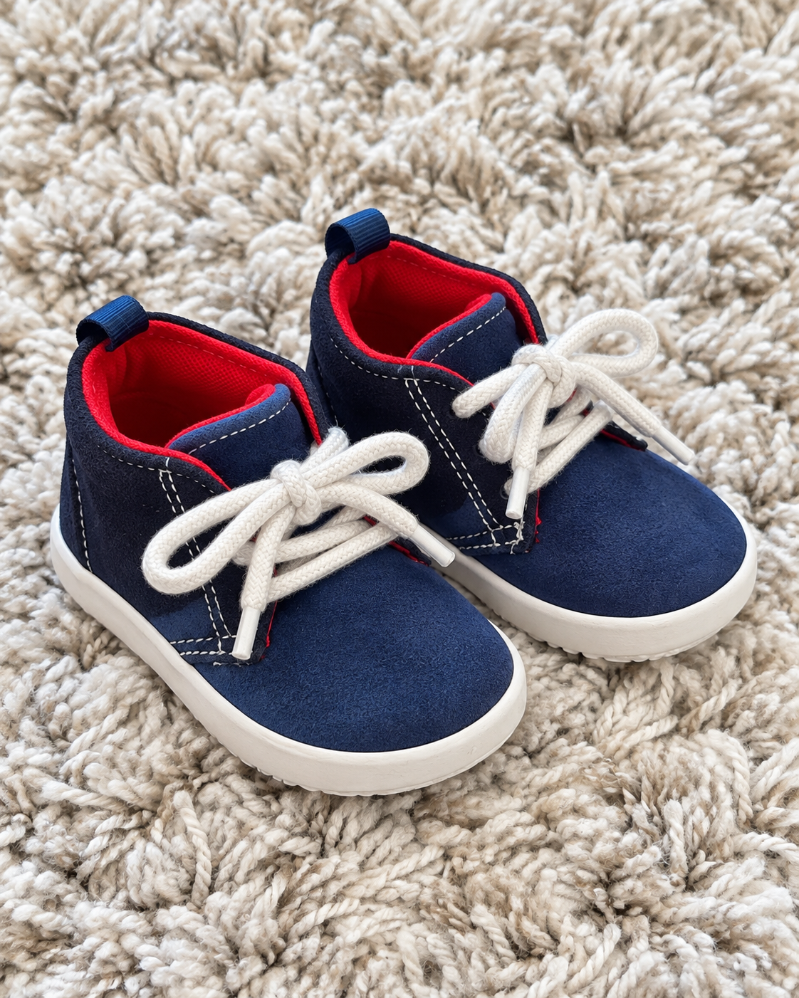 Navy and red baby sneakers angled view