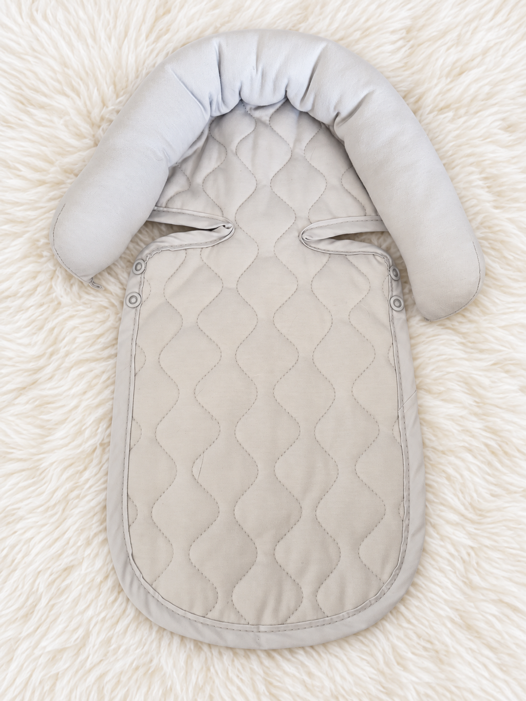 Light gray quilted infant support insert front on white rug