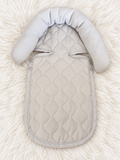 Light gray quilted infant support insert front on white rug