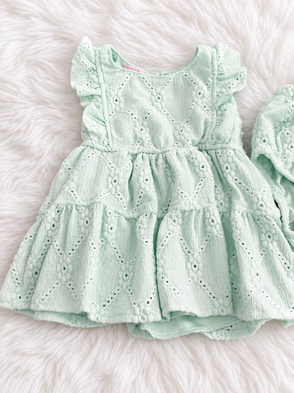 Mint eyelet dress detail on white rug