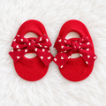 Red heart bow baby sock shoes on white rug