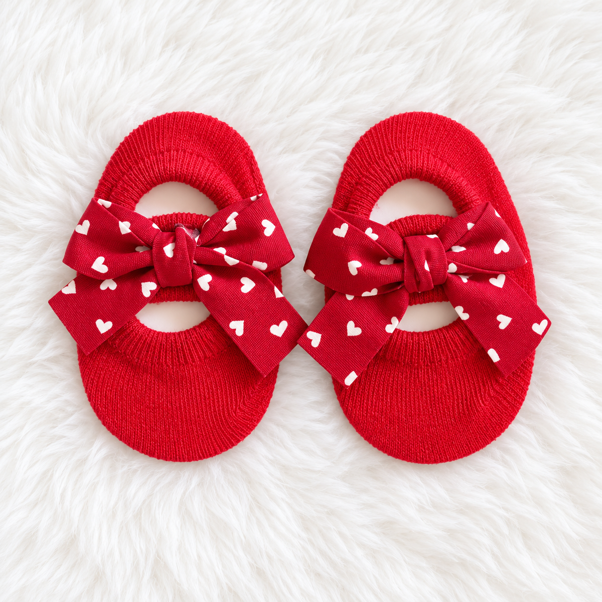 Red heart bow baby sock shoes on white rug