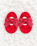 Red striped bow baby sock shoes on white rug
