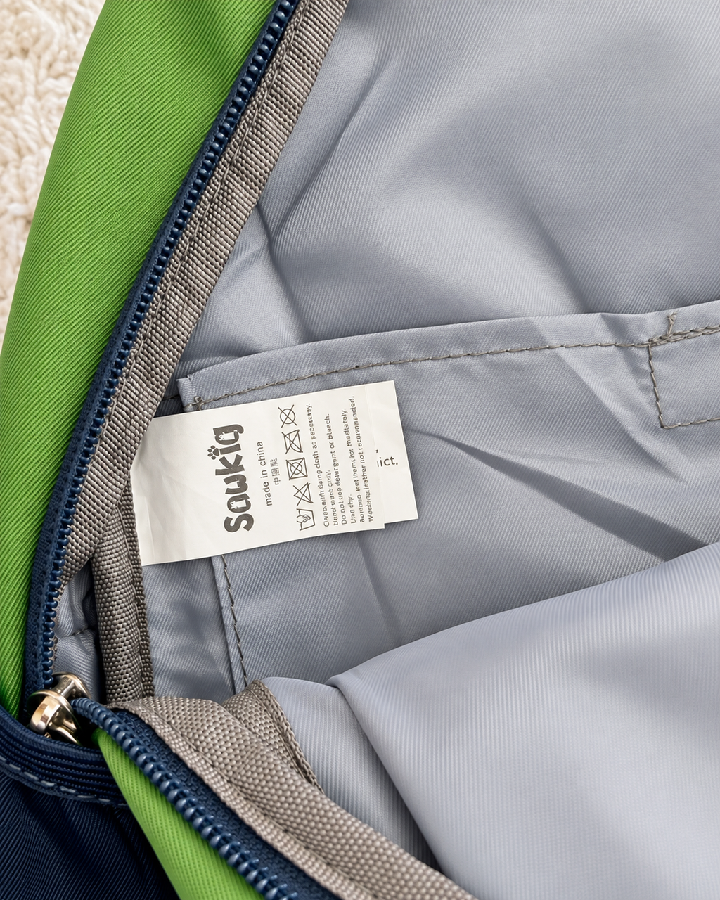 Sawkig kids backpack interior and care tag