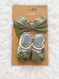 Olive green bow headwrap with matching white and olive booties on original display card