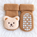 Tan bear baby non-slip socks on white rug background